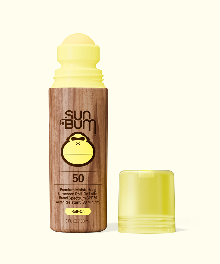 Sun Bum Original SPF 50 Sunscreen Roll-On Lotion with wooden texture and yellow cap beside it