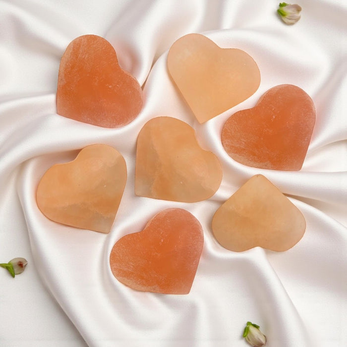 Peach selenite hearts on white satin