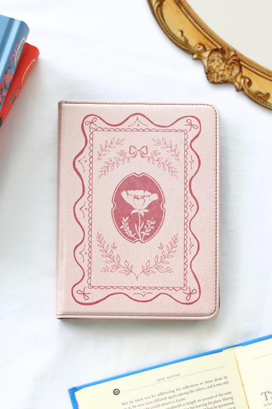 Pink kindle with decorative cover on a white surface