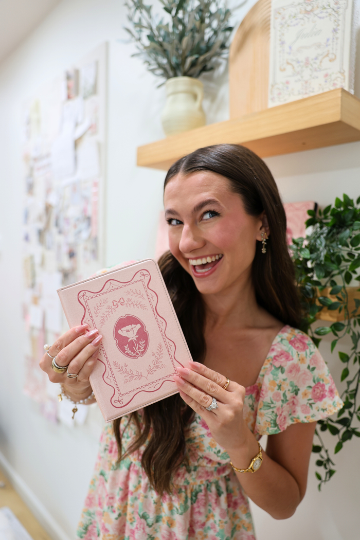 girl holding a pink kindle case