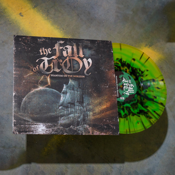 A limited edition green & yellow mixed vinyl with black splatter from The Fall of Troy peeks from its sleeve, which features ghost ship and moon artwork. The cover text reads The Fall of Troy - Phantom on the Horizon.