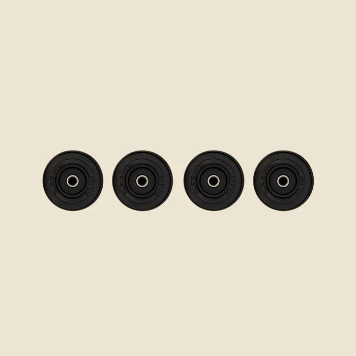Set of 4 Guide Wheels for the Pilates Reformer  in front of Beige Background.