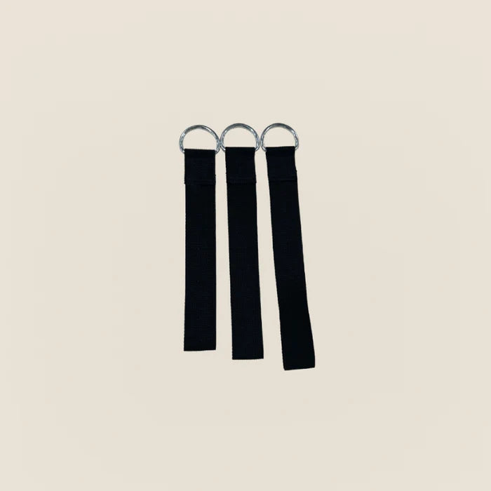 Three black Pilates neck stretcher straps with metal D-rings on a beige background.