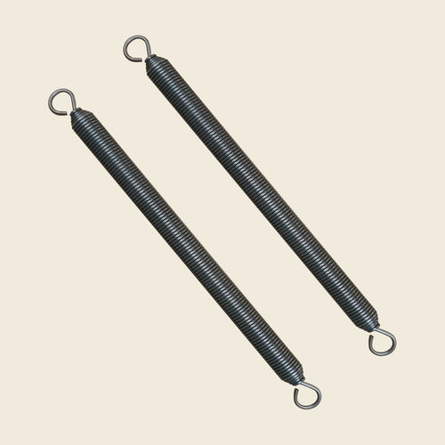Pair of coiled steel Wunda Chair springs with looped hooked ends on beige.