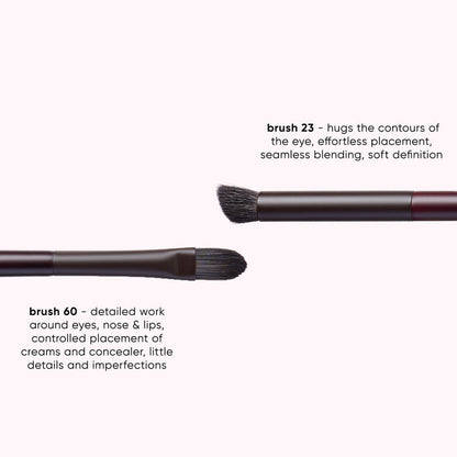 Three makeup brushes shown on a pale pink background with descriptive text labels: brush 23, brush 60, and a third brush partially visible. The brushes have dark bristles, black ferrules, and dark metallic handles.