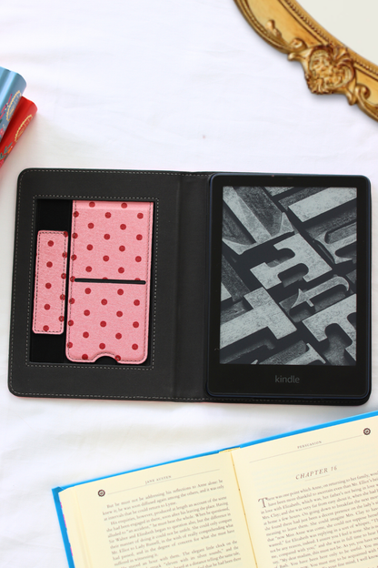 Black leather-bound kindle with pink polka dot pattern on a white surface