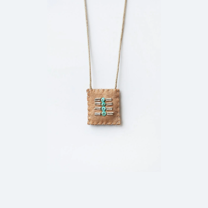 Beaded talisman necklace with turquoise bead accents on tan fabric pouch
