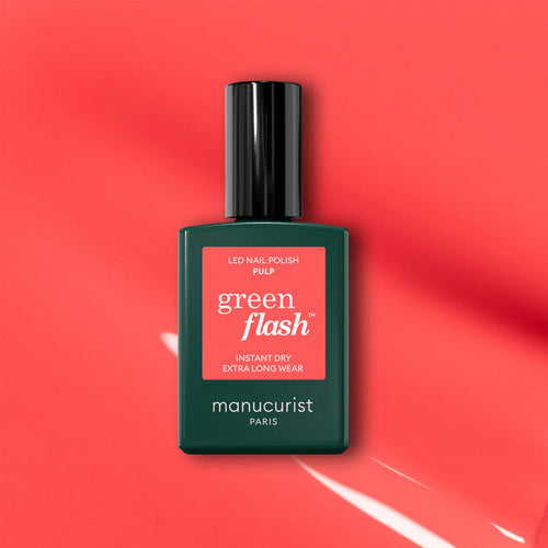 A bottle of Manucurist Pulp gel polish is displayed on a coral pink background with light reflections. The label reads "Pulp, Instant Dry, Extra Long Wear.