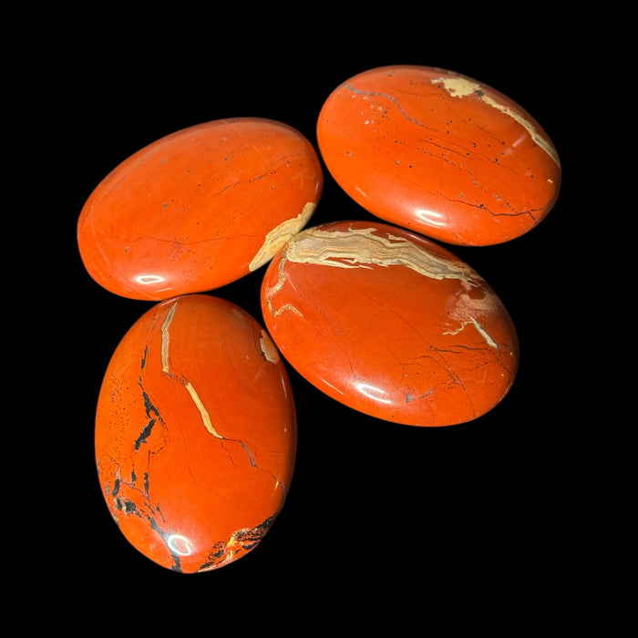 Shop Red Jasper Palm Stones at Raven’s Cauldron. Each 80g stone, ~2.75 inches long, is mined in Brazil and polished to showcase beautiful reds and whites. Perfect for grounding and healing.