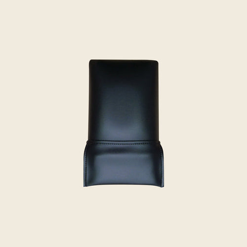 Black upholstered replacement head rest cushion for a Pilates Reformer, shown on beige.