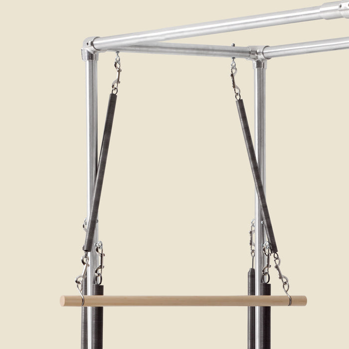 Wooden roll down bar suspended by springs and S hooks from a Cadillac frame.