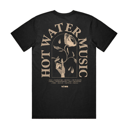 Photo of the back of the shirt. The back of the shirt has the band name "HOT WATER MUSIC" arched around a hand holding a rose. There is also very small text underneath the main design that is unreadable in the photo.