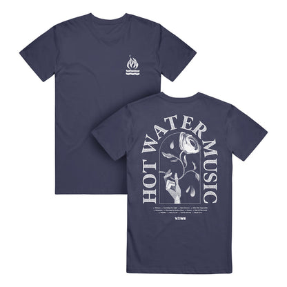 Hot Water Music navy Comfort Colors T-Shirt made of soft ring-spun cotton; features a small flame and wave logo on the chest and a large back graphic of a hand holding a wilting rose dripping water with HOT WATER MUSIC text.