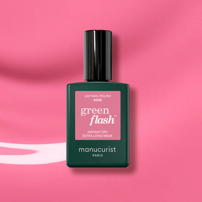 Manucurist Rose gel polish, featuring a dark green cap and label, is displayed against a glossy pink background.
