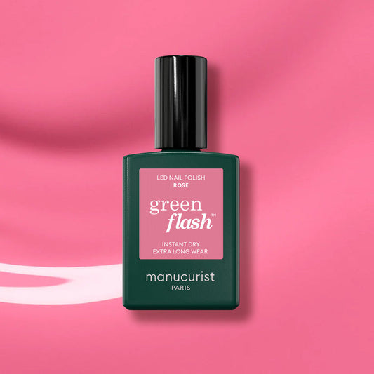 Manucurist Rose gel polish, featuring a dark green cap and label, is displayed against a glossy pink background.