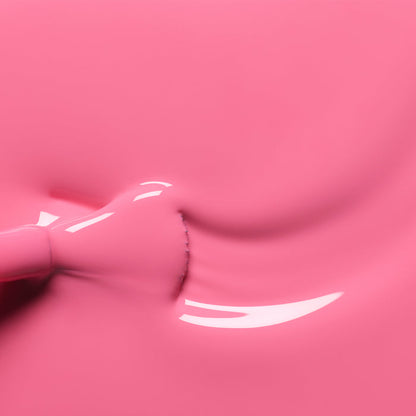 Close-up of Manucurist’s Rose pink nail polish spreading smoothly, showing glossy reflections on the liquid surface as a brush is partially visible on the left.