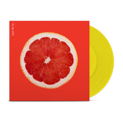 Bright orange colored vinyl jacket with an image of the inside of a grapefruit. In the top left corner there is vertical white text that says SAVES THE DAY. Peeking out of the jacket is a yellow vinyl.