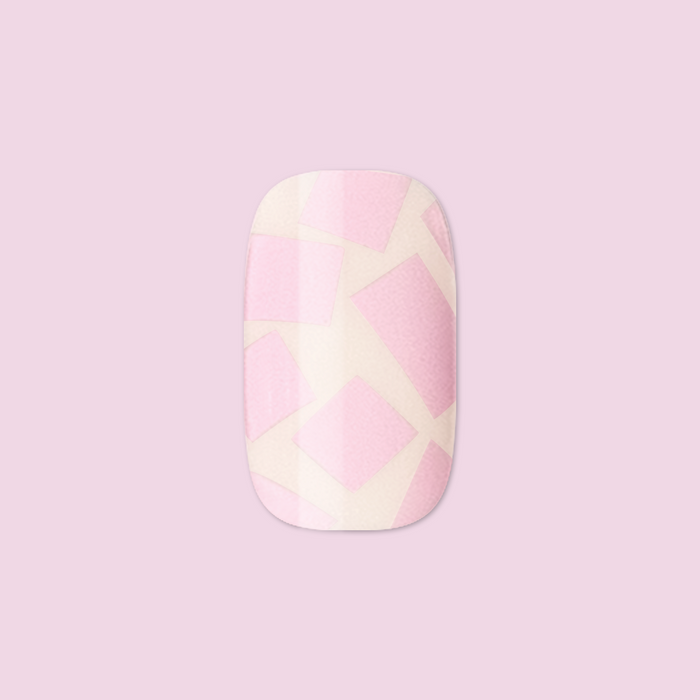 Scattered Squares | Short | Squoval - Tab Press-On light pink press-on nail with scattered square design on soft pink background