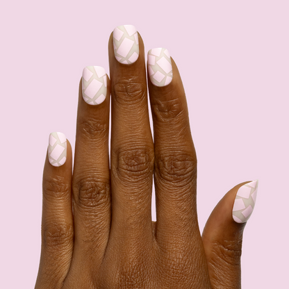 Scattered Squares | Short | Squoval - Tab Press-On light pink press-on nails with abstract square shapes on hand against pale pink background