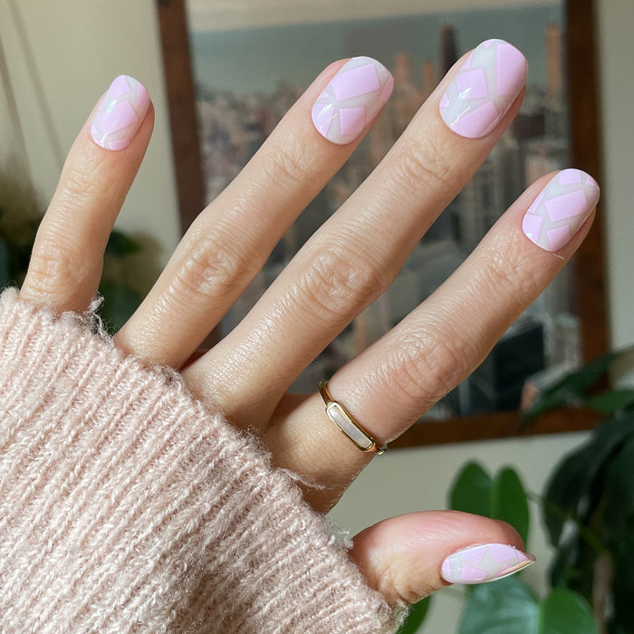 Scattered Squares | Short | Squoval - Tab Press-On light pink press-on nails with geometric square accents on hand wearing soft knit sweater