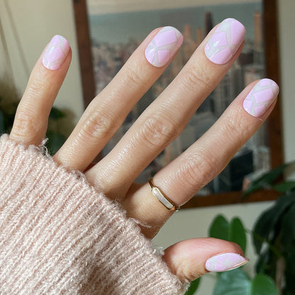 Scattered Squares | Short | Squoval - Tab Press-On light pink press-on nails with geometric square accents on hand wearing soft knit sweater