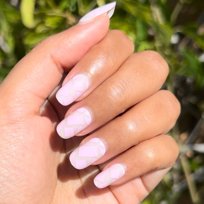 Scattered Squares | Short | Squoval - Tab Press-On light pink press-on nails with subtle square pattern on hand in natural sunlight outdoors