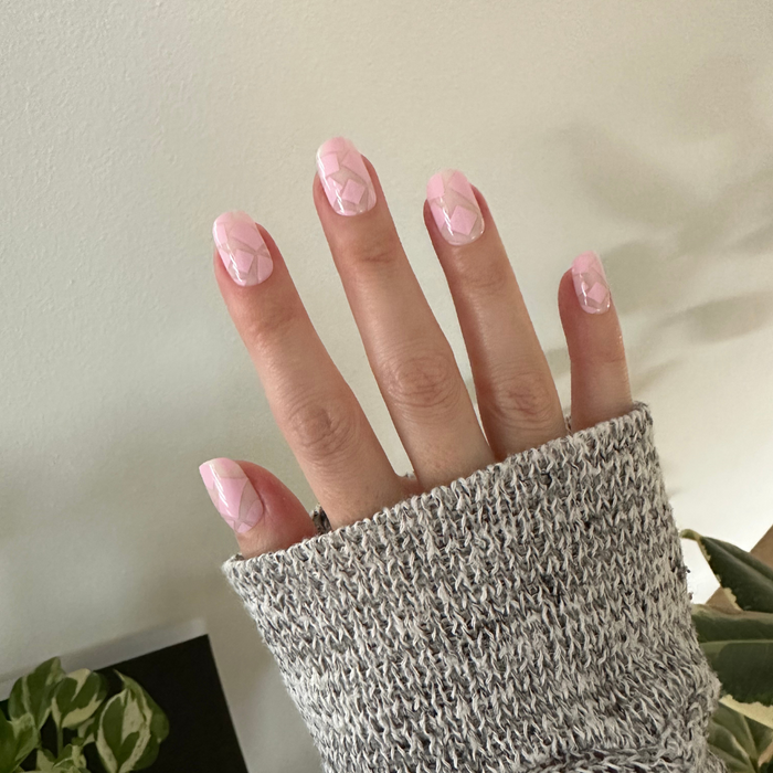 Scattered Squares | Short | Squoval - Tab Press-On light pink press-on nails with subtle square details on hand in cozy knit sleeve