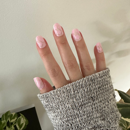 Scattered Squares | Short | Squoval - Tab Press-On light pink press-on nails with subtle square details on hand in cozy knit sleeve