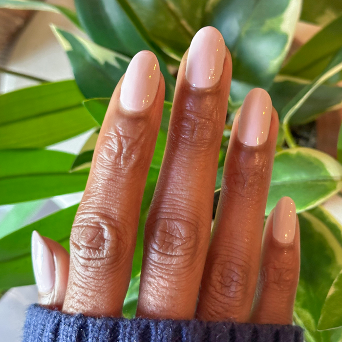 Hand with Sculpture Wing | Short | Round - Tab Press-On nails in soft cool lavender grey shade against green leaves background