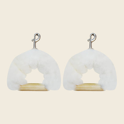 Pair of genuine sheepskin covers wrapping wooden Pilates reformer handles with metal clips.