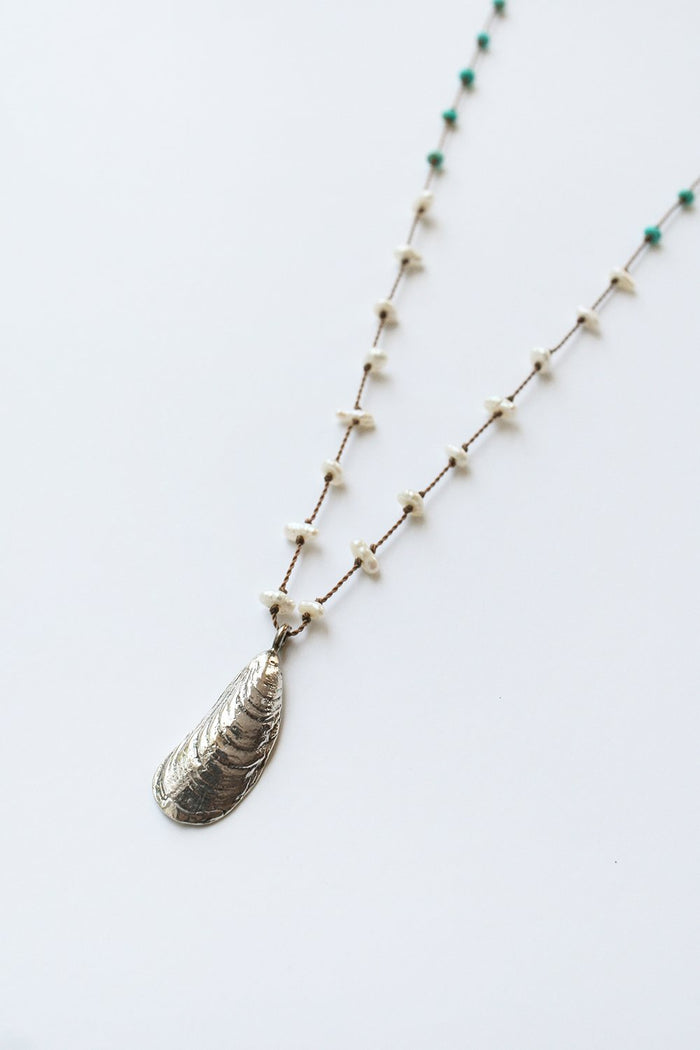 Silver shell pendant necklace with turquoise beads and white accents