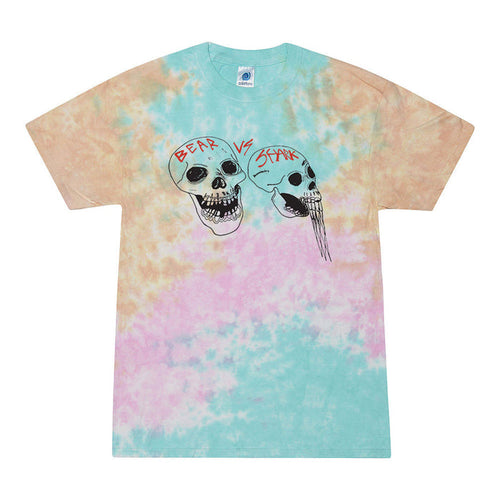 A limited edition bearvsshark Colortone tie-dye t-shirt with two illustrated skulls (bear and shark) and “VS” between them, designed in exclusive blue, pink, and tan pastels.