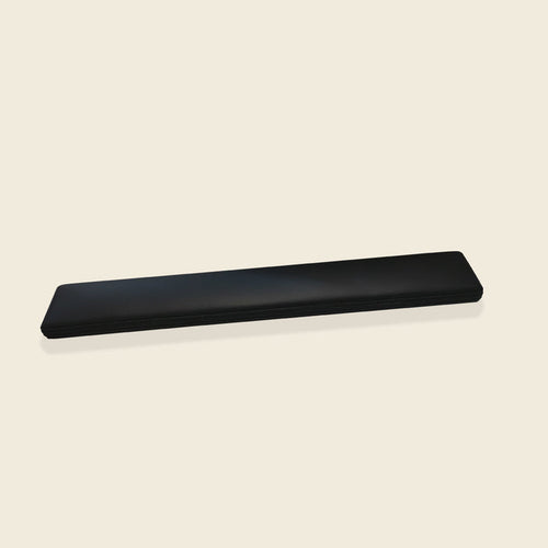 Gratz Pilates small foot board with black upholstered padding on a neutral background.