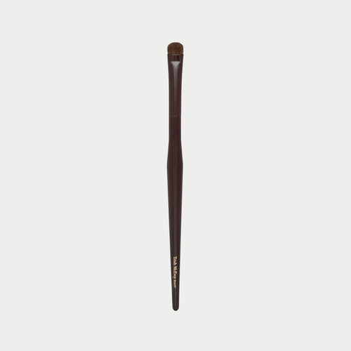 Makeup brush 54 with brown handle and black bristles on a white background