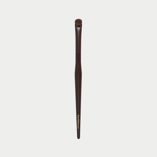 Makeup brush 54 with brown handle and black bristles on a white background