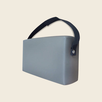 Grey upholstered Gratz Pilates spacer box with a black carrying strap handle.