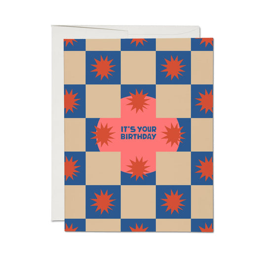 Birthday card with blue checkered design, orange bursts, and 'It's Your Birthday' text.