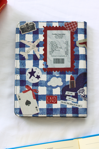 Kindle with a blue and white checkered cover featuring travel-themed stickers on a white background.