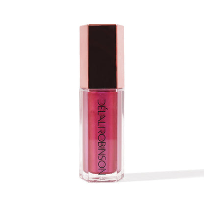 A tube of nude-colored lip gloss with a pink tint and a brown cap, labeled 'Delal Cosmetics'.