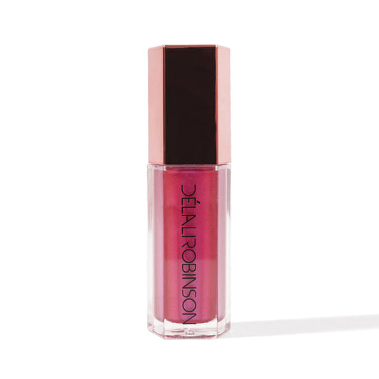 A tube of nude-colored lip gloss with a pink tint and a brown cap, labeled 'Delal Cosmetics'.