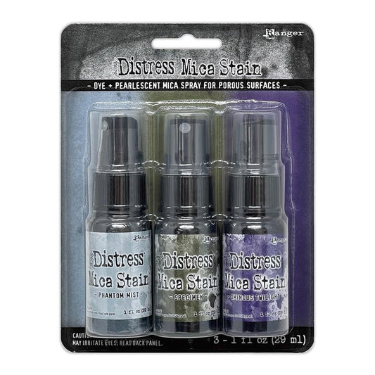 Tim Holtz - Distress Mica Stain Set - Halloween Set# 6. Tim Holtz Distress Mica Stains are a colorful elixir of pearlescent shimmer for mixed media and papercraft projects. This set includes colors Phantom Mist, Specimen and Ominous Twilight. Available at Embellish Away located in Bowmanville Ontario Canada.