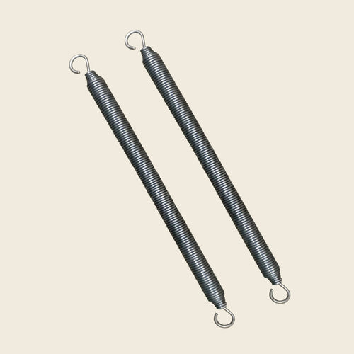 Pair of Gratz Pilates trapeze bar springs with open hook ends on beige.
