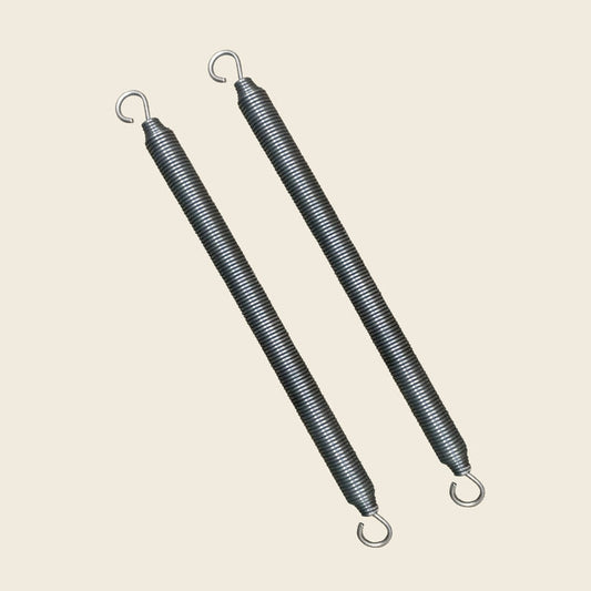 Pair of Gratz Pilates trapeze bar springs with open hook ends on beige.