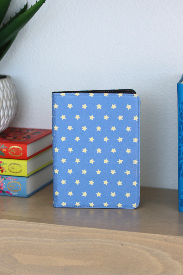 Blue Kindle Case with star pattern on a wooden surface