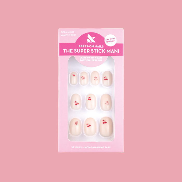 Vampy Cherry | Extra Short | Round - Tab Press-On nails in pastel pink with red cherry design in packaging on pink background