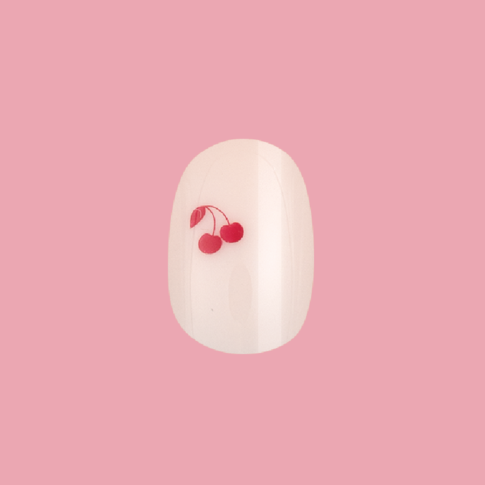 Vampy Cherry | Extra Short | Round - Tab Press-On nail in pastel pink with red cherry design on single nail against pink background