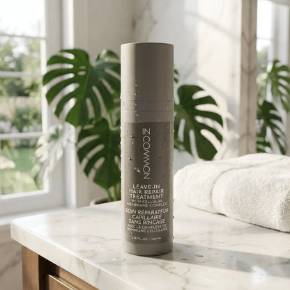 Leave-in hair repair treatment bottle with water droplets on a bathroom counter